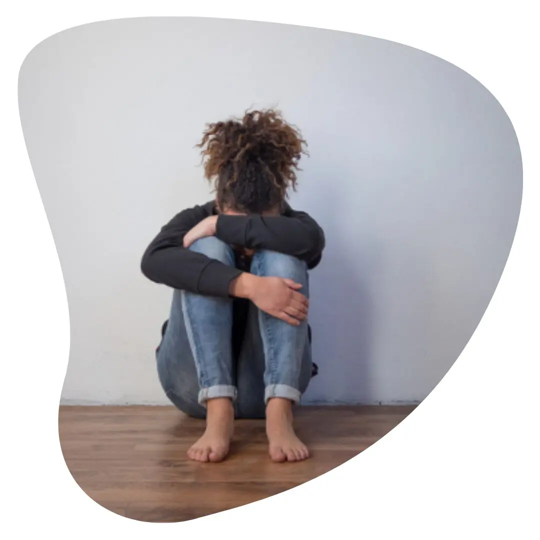 Sad and lonely black girl feeling alone | Atlanta trauma therapy | 30263 | 30044 | 30179 | 30268 | 30809 Sad and lonely black girl feeling depressed sitting on floor with head in lap and in need of trauma therapy