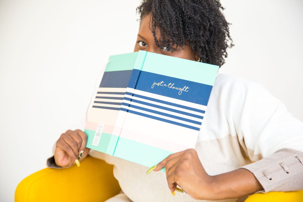 Image of a black woman holding a book over her face. Are you looking for an Atlanta anxiety therapist? We offer anxiety therapy through online therapy in Georgia. Anxiety symptoms do not have to rule your life anymore. Start getting anxiety help in Atlanta, GA. Call today!