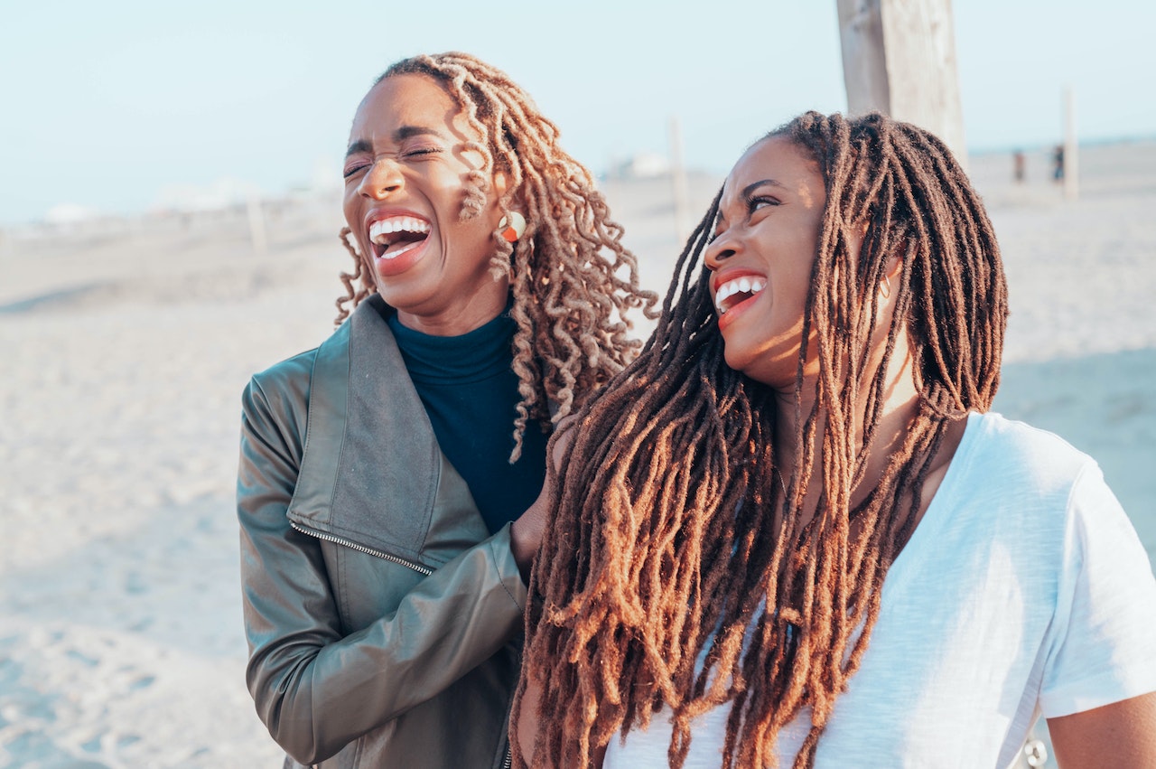 Image of two black women laughing together. Representing the benefits for seeing a black female therapists for therapy in Atlanta, GA. Which allow you to be your authentic self
