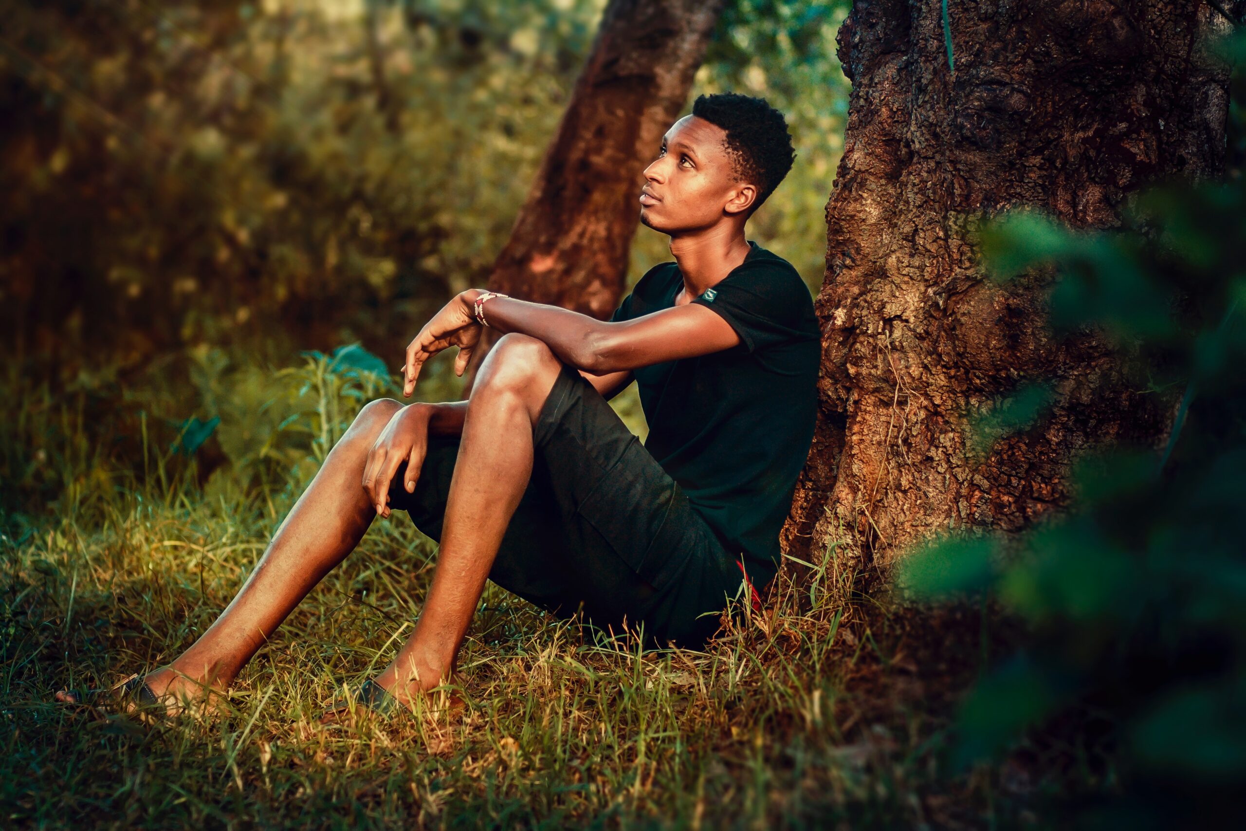 Image of an african american man sitting in a forest. Representing someone that may benefit from therapy with a black female therapist in Atlanta, GA. Be your authentic self.