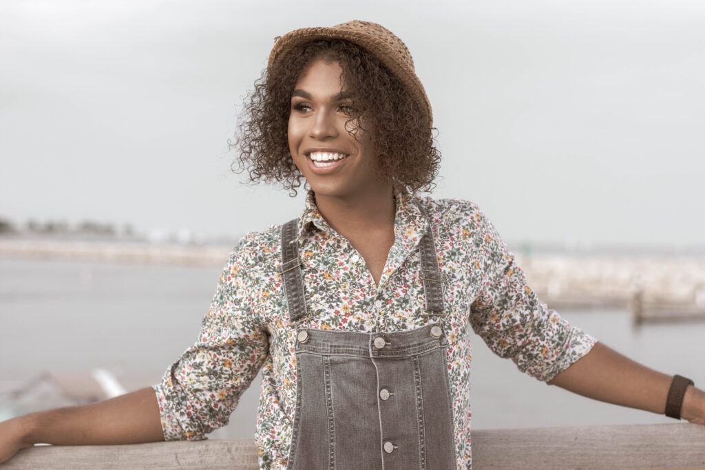 Image of a black trans woman smiling standing in front of water. Representing someone who could benefit from LGBTQ therapy in Atlanta, GA. Whether for depression or anxiety an LGBTQ therapist can give support to you through LGBTQIA therapy.
