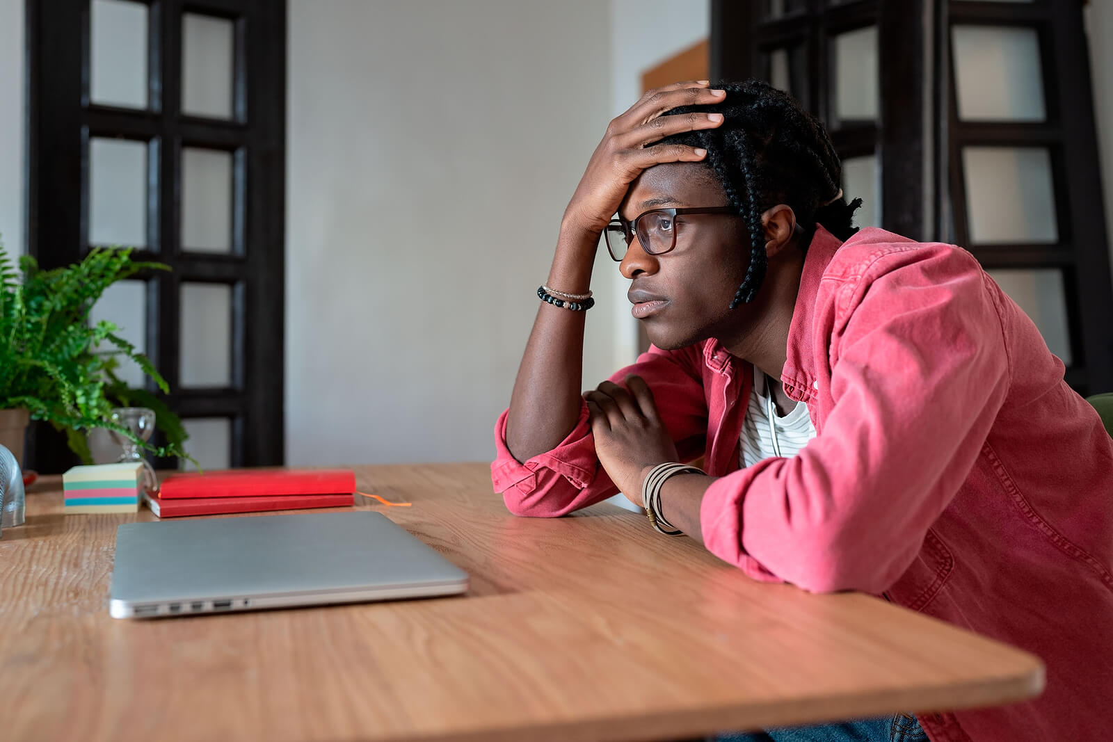 Image of a Black man sitting at his desk looking upset. Showing someone who could benefit from therapy for African American males in Atlanta. Where Black female therapists can provide support through therapy for Black men.