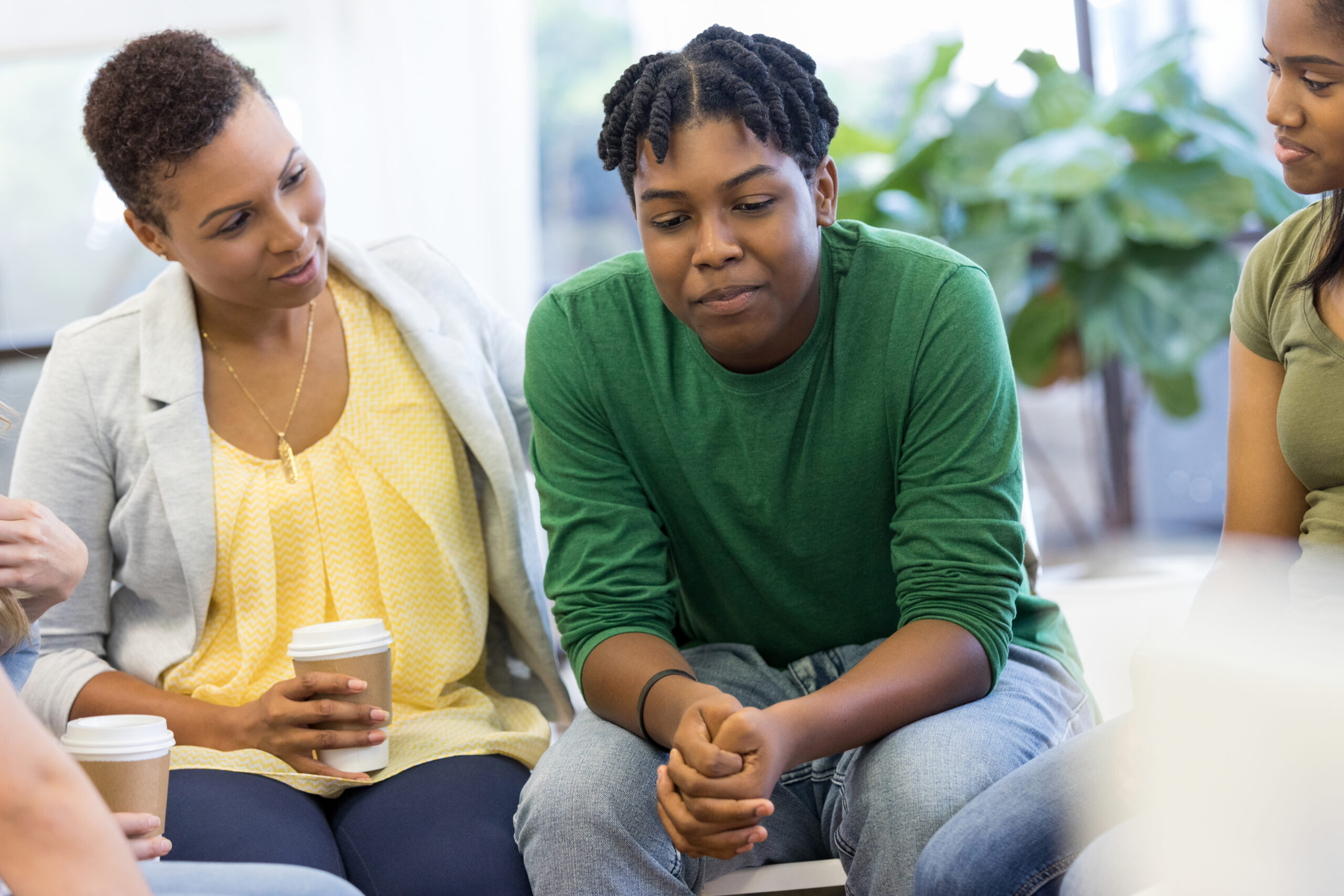 Image of a woman in a green shirt taking part in group therapy in Atlanta, GA. Showing what to expect from anxiety group therapy in Atlanta. Where a group therapist can guide and support you.