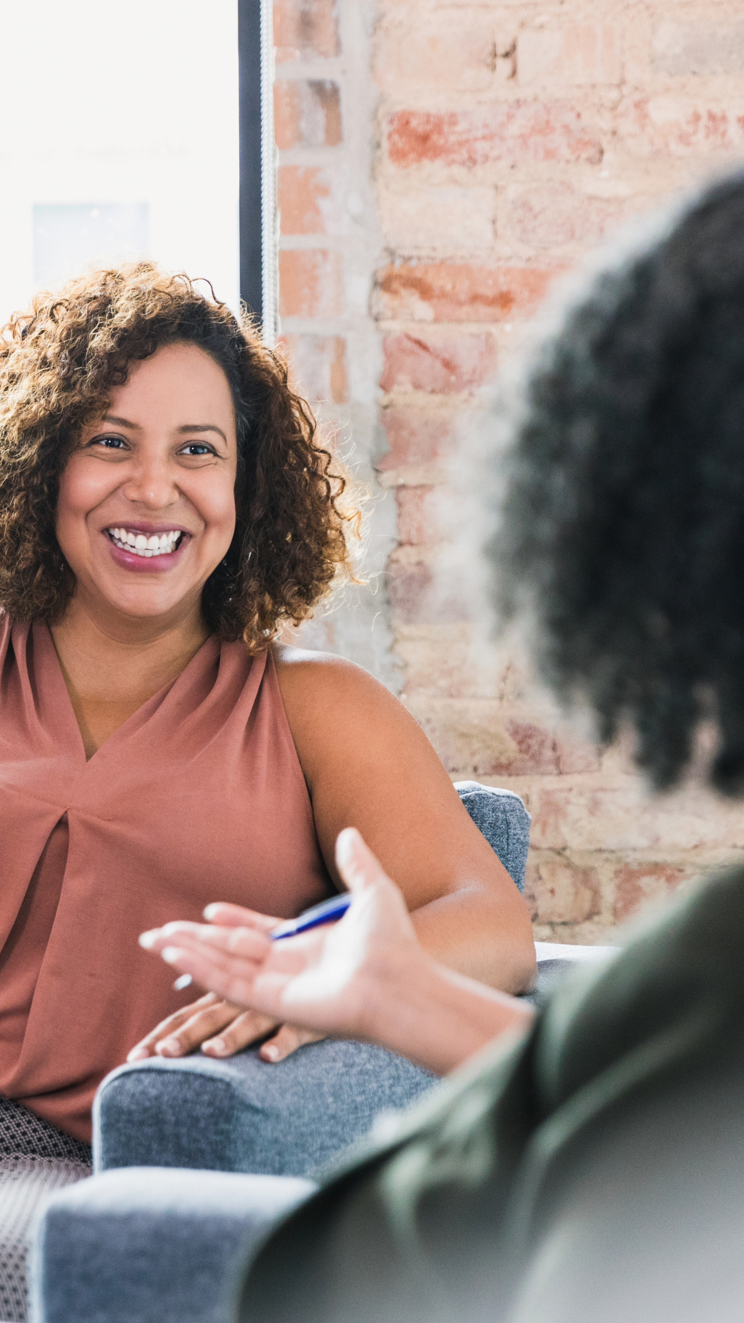 Image of a Black woman seated in conversation while speaking to a Black female therapist. Showing one way that therapy can provide relief. Talking with a therapist can help reduce mental health symptoms in Atlanta, GA